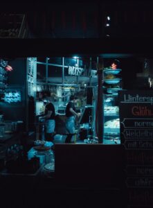 Street cafe employees working at counter at night